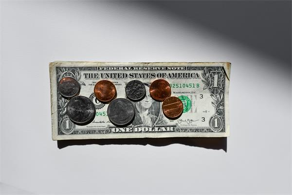 seven coins on a US $1 bill seven coins on a US $1 bill with a shadowed white background